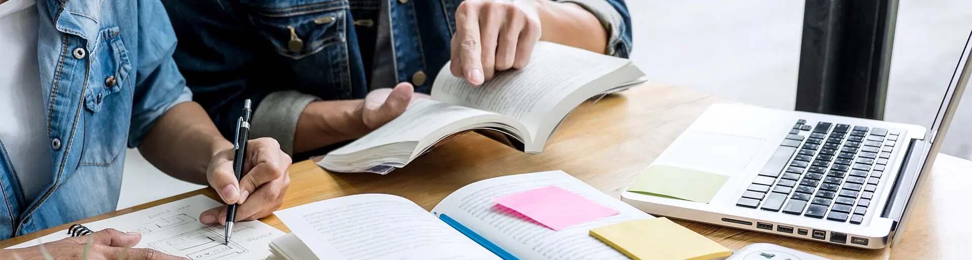 Student working on schoolwork at table with parent