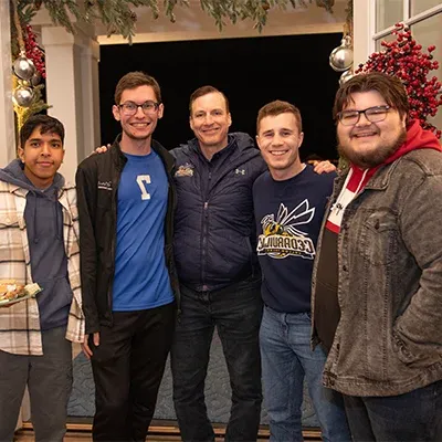 Dr. White smiling with students at his house.